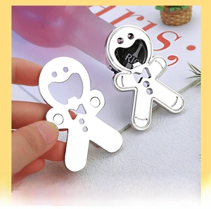Creative gingerbread man metal bottle opener being used on a colorful beverage bottle cap
