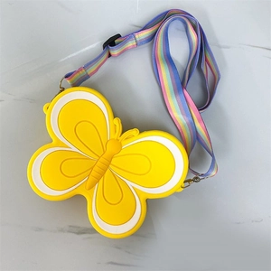 Detail of yellow silicone butterfly bag with adjustable rainbow strap on marble surface