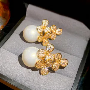 Elegant gold flower earrings with white pearls and sparkling cubic zirconia stones