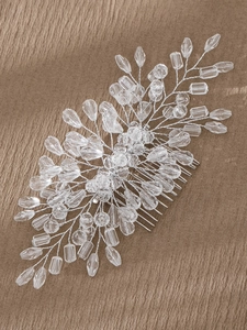 Detail of handmade bridal hair comb with crystal beads and silver wire on brown fabric