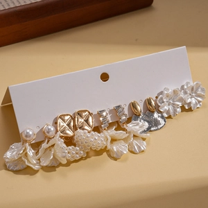 Zehnteiliges Gold-Ohrring-Set mit weißen Perlen und Strasssteinen auf Display
