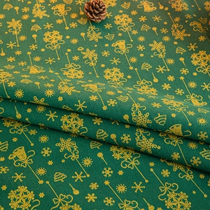 Green Christmas tablecloth with golden foil snowflakes, bells and tree patterns