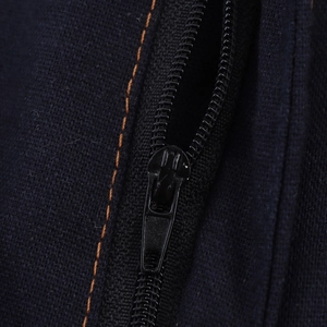 Detail of dark blue fabric with orange contrast stitching and high-quality black zipper