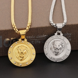 Macro shot of gold and silver lion head pendants with box chain on dark background