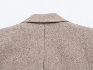Close-up detail of herringbone wool blend fabric on the collar and back of the blazer
