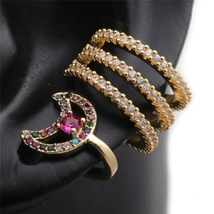 Macro detail of gold geometric ear cuffs with zircon and multi-color gems on black model