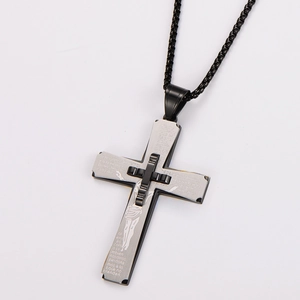 Detail view of silver cross pendant with Spanish Lord's Prayer engraving on black base