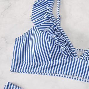 Detail of blue and white striped bikini top with ruffle edges and ribbed fabric texture