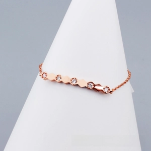 Detail of rose gold geometric hexagon bracelet with five sparkling cubic zirconia stones