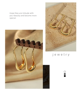 Detailed view of irregular geometric U-shaped earrings with polished gold finish