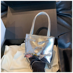 Macro shot of a silver metallic bow bag with bead chain inside a black gift box