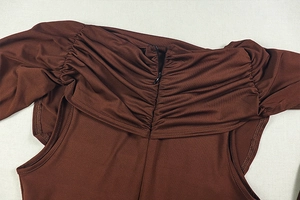 Detail of coffee brown jumpsuit featuring center hidden zipper and ruched fabric texture