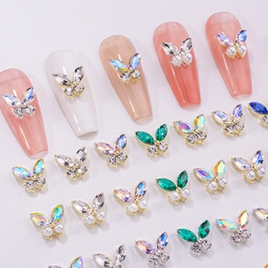 Detailed macro of 3D alloy butterfly nail charms with colorful zircons and pearls