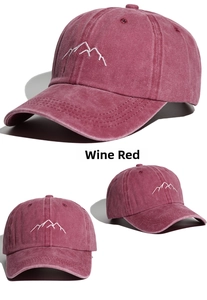 Detail of wine red washed cotton baseball cap featuring mountain embroidery and vintage texture