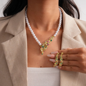 Vintage gold flower necklace set with pearls and vibrant rhinestones on a model