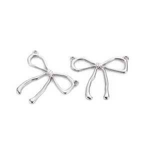 Macro shot of silver bow pendants for DIY jewelry making with smooth metallic finish