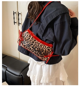 Detail of leopard print shoulder bag with red patent leather trim and bow knot