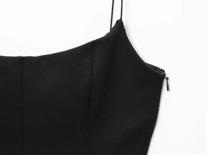 Detailed view of black camisole with thin straps and hidden side zipper closure