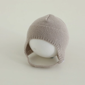 Dettagli del cappello in maglia beige per neonati con trama morbida e paraorecchie