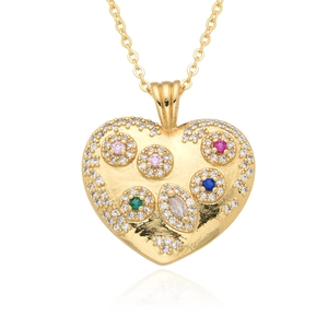 Macro detail of gold heart pendant featuring colorful zircon stones and fine chain