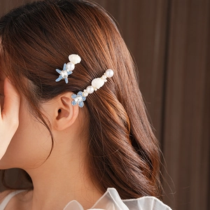 Détail de barrettes étoile de mer et coquillages avec strass bleus et perles