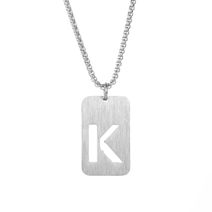 Detail of silver titanium steel square pendant with cutout letter K on a box chain