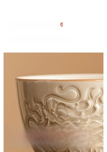 Macro detail of Chinese dragon relief on ceramic teacup with elegant brown rim