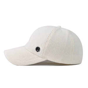 Beige knitted baseball cap with M logo and textured fabric in a 45-degree side view