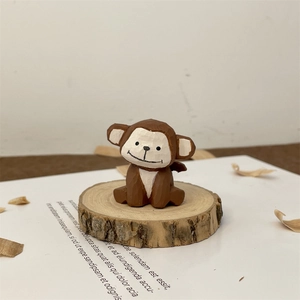 Hand-carved wooden monkey figurine with detailed texture on a rustic timber stand