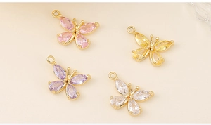 Detailed close-up of zircon butterfly charms in pink, yellow, purple and white colors