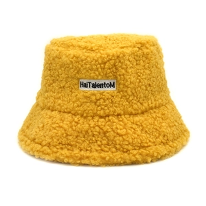 Détail du bob en polaire sherpa jaune avec écusson brodé du logo HaiTalentoM au centre