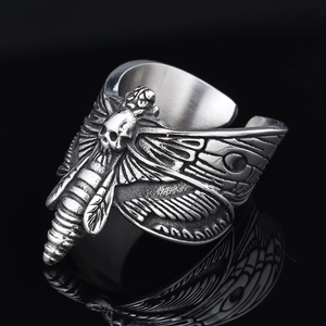 Gothic stainless steel open ring with silver skull moth relief on a black background