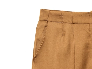 Detail shot of brown satin wide-leg pants showing smooth fabric texture and neat stitching