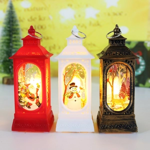 Three Christmas lantern decorations with Santa, Snowman and Reindeer patterns on the desk
