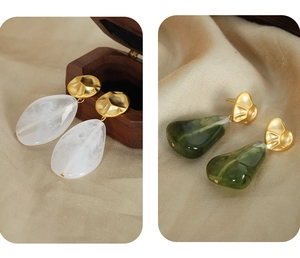Detailed shot of vintage marble resin drop earrings in white and emerald green finishes