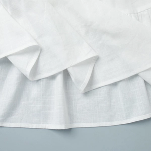Detailed view of the white cotton-linen fabric with neat stitching and natural texture