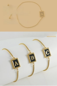 Détail du bracelet chaîne en or réglable avec breloques lettres en émail noir