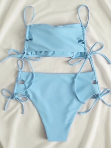 Detailed flat lay of light blue bikini featuring drawstring side ties and ribbed fabric