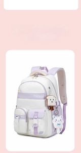 Detail of white and purple backpack with multiple pockets and cute plush charms