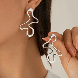 Close-up of silver wavy hollow earrings showing polished texture and elegant fit