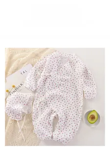 Floral baby bodysuit and sun hat set on a cozy lace blanket with decorative magazines