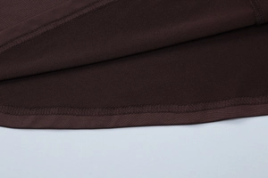 Macro detail of the French style brown dress showing precise double-needle stitching quality
