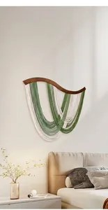 Décoration murale bohème avec franges vertes incurvées et support en bois naturel