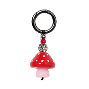 Detail of red acrylic mushroom pendant with colorful beads on a black metal keychain