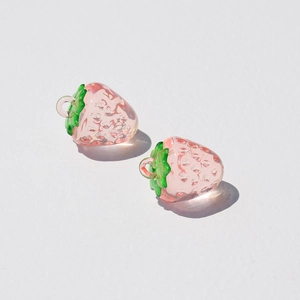 Detailed macro view of pink acrylic strawberry charms for DIY jewelry making accessories