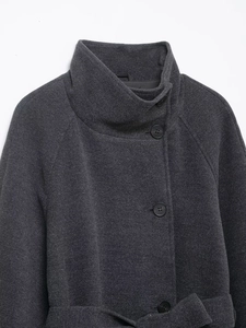 Detail view of dark grey wool coat with stand-up collar and black round buttons texture