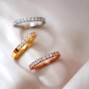 Three minimalist titanium steel rings in gold, silver, and rose gold with CNC set crystals