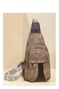 Detail of vintage brown faux leather crossbody bag with geometric pattern woven strap