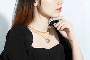 Detail of layered gold titanium necklace featuring intertwined rings on a model