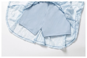 Detail of light blue lace dress showing built-in safety shorts and floral mesh texture